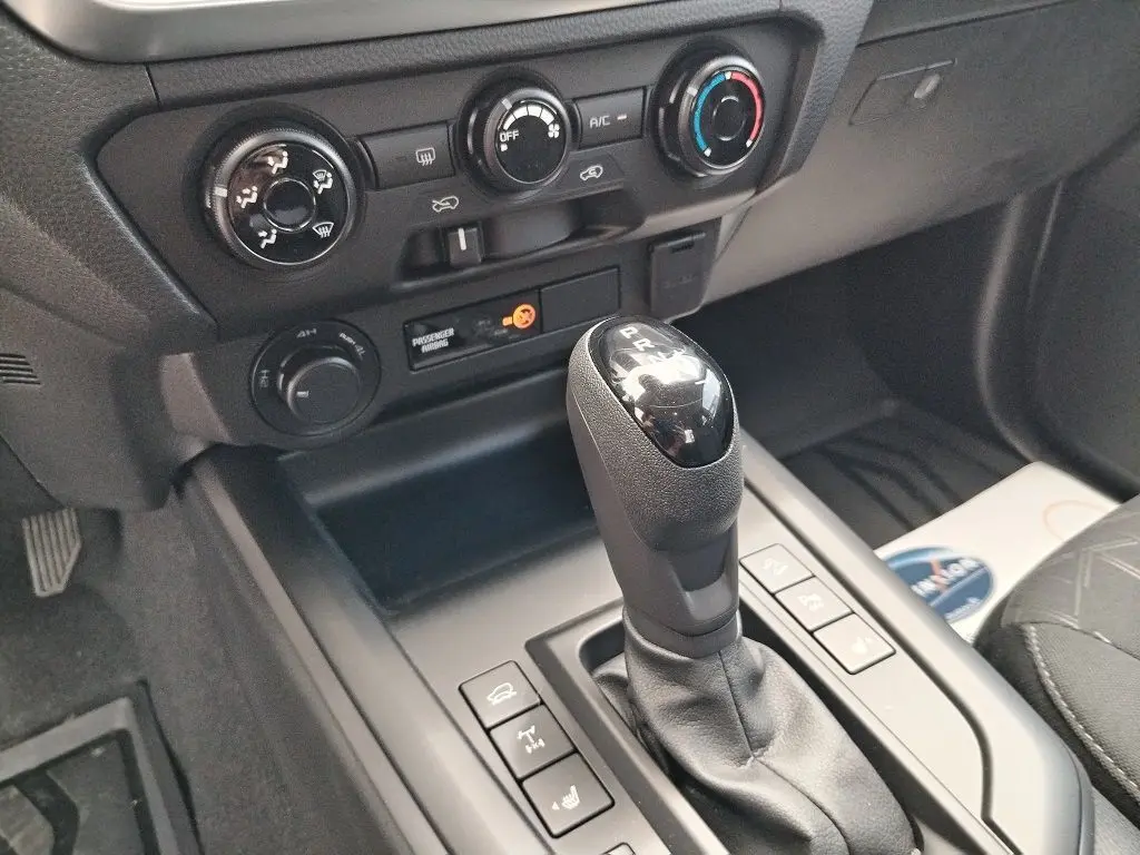 Gros plan sur la console centrale et levier de vitesse automatique du pick-up Isuzu D-MAX 2026, intérieur noir.
