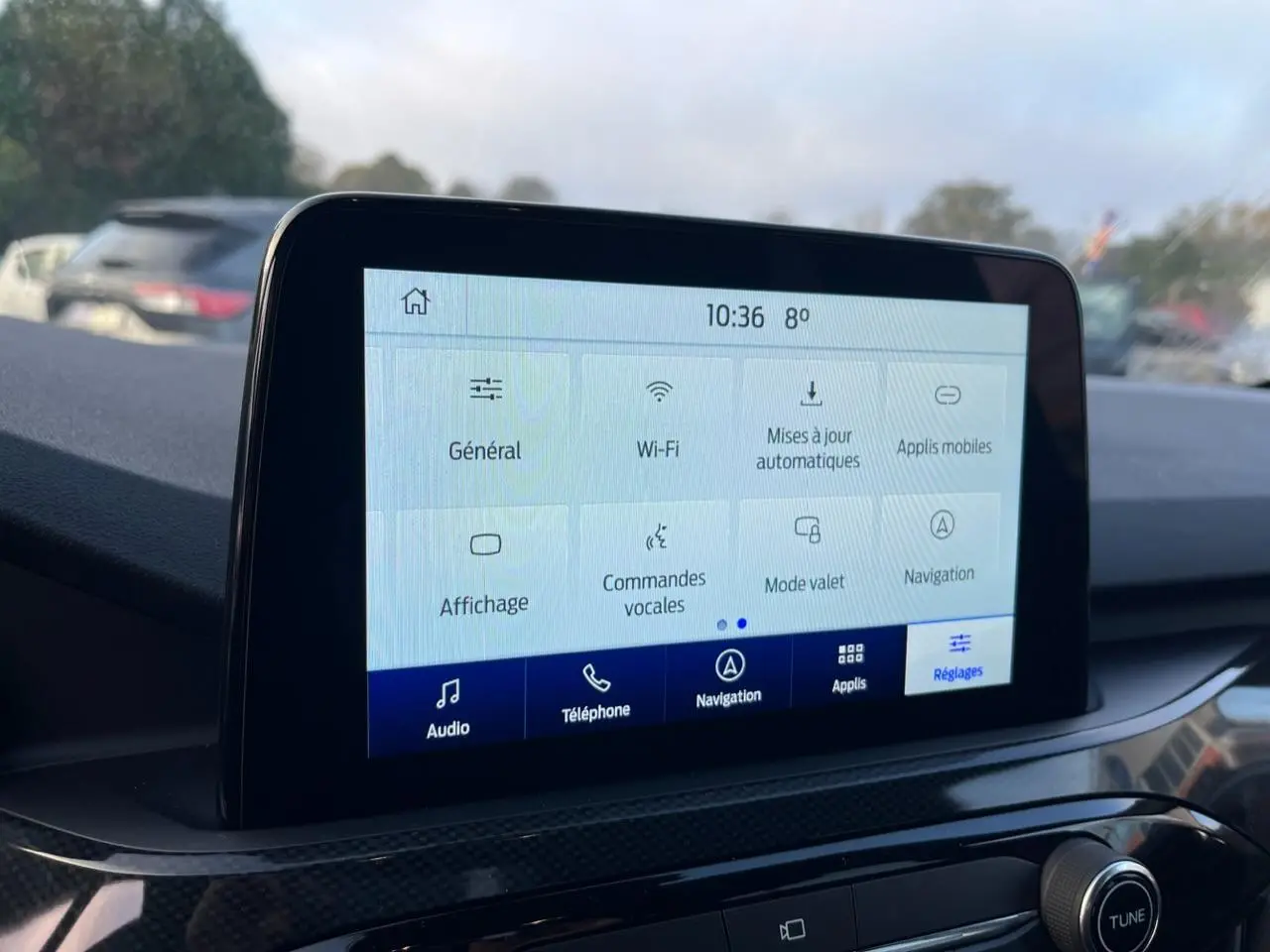 Écran tactile central du Ford Kuga 1.5 EcoBoost 2022 affichant le menu des réglages, intérieur noir.