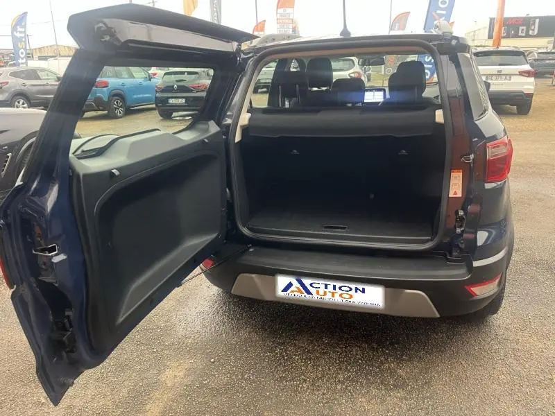 Vue arrière du Ford EcoSport Bleu Abysse 2021 avec coffre ouvert et banquette arrière visible dans un parking extérieur.