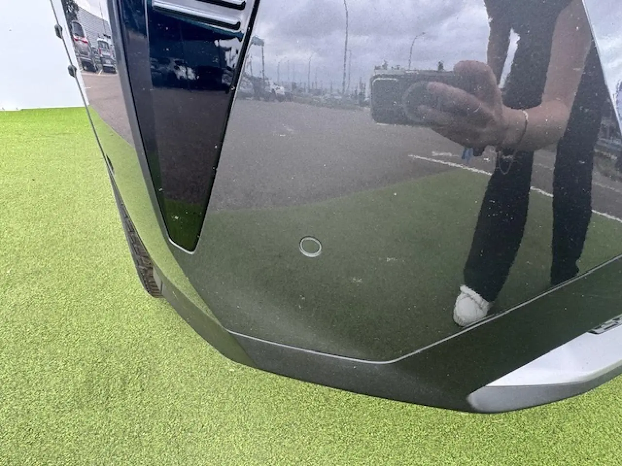 Gros plan sur le pare-chocs avant gris titane du Peugeot 3008 II avec capteur de stationnement visible.