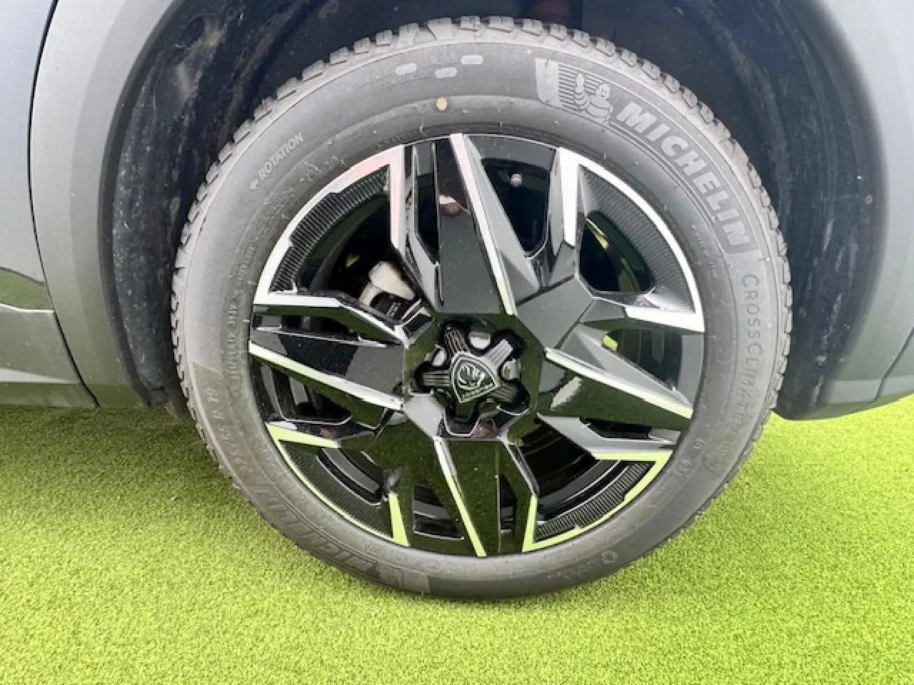 Gros plan sur la roue avant droite du Peugeot 3008 gris titane avec jante alliage noire et argentée diamantée.