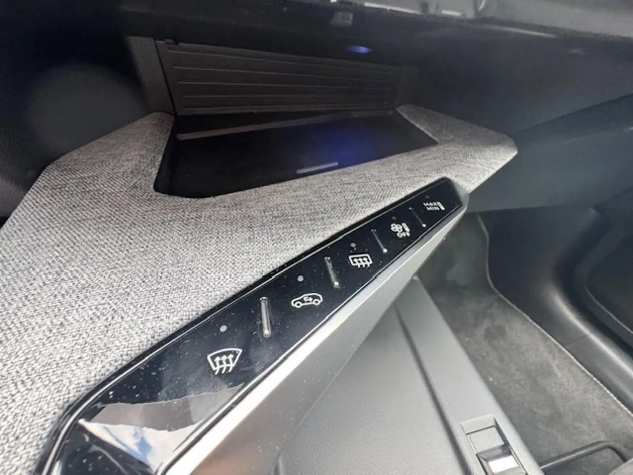 Détail de la console centrale avec commandes tactiles sur décor tissu gris clair dans un Peugeot 3008 gris titane 2024.
