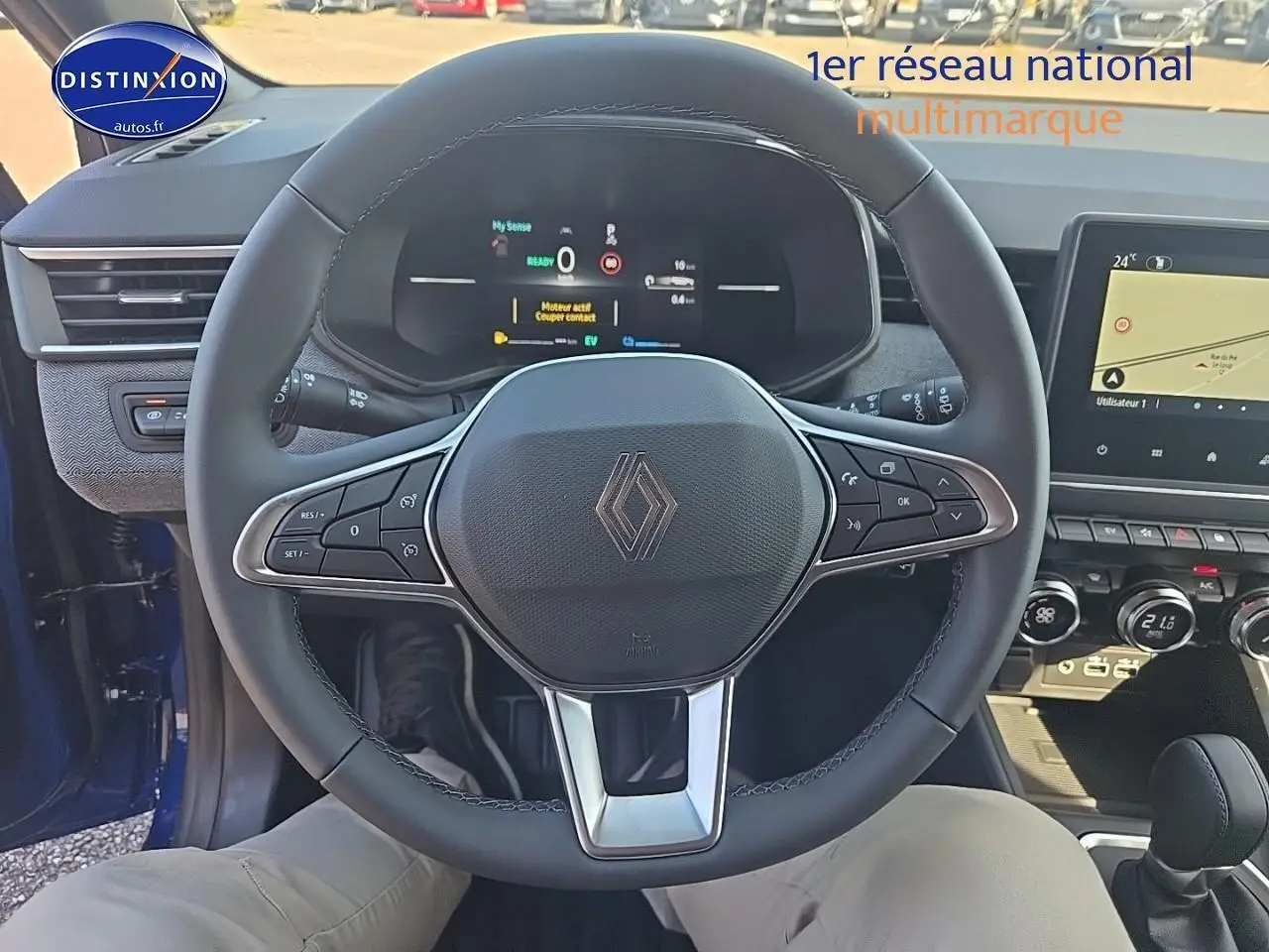 Vue intérieure centrée sur le volant multifonction de la Renault Clio V 1.6 e-tech bleu iron avec tableau de bord numérique.