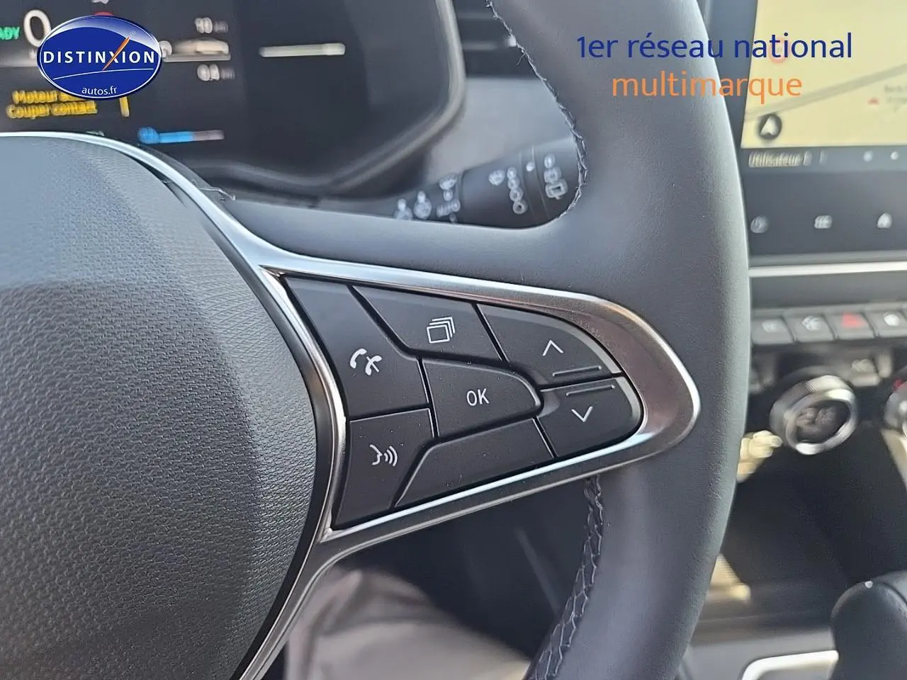 Gros plan sur les commandes multifonctions du volant noir de la Renault Clio V 1.6 e-tech 145 techno 2025.