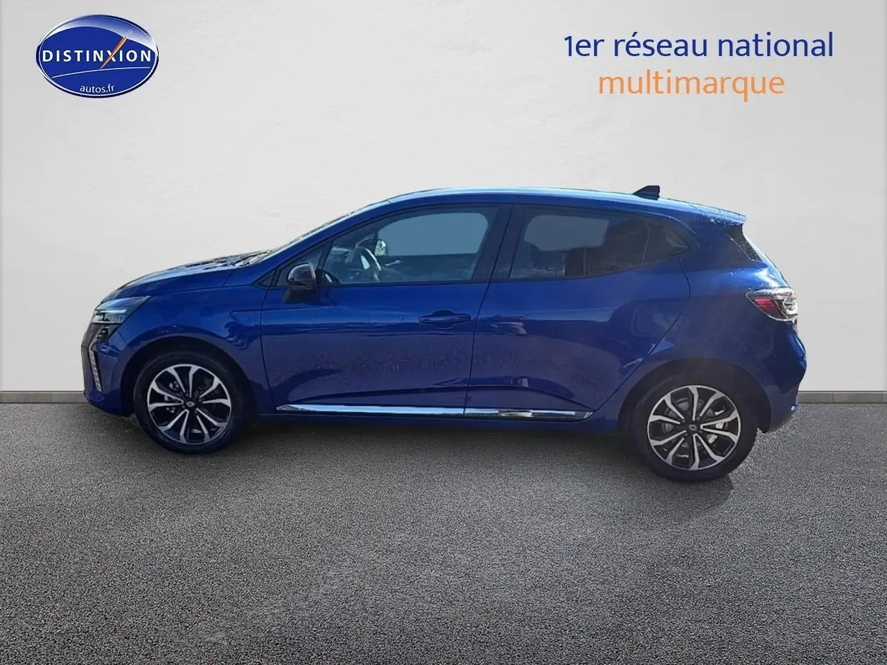 Profil droit d'une Renault Clio V 1.6 e-tech 145 techno bleu iron avec jantes alu et poignées ton carrosserie.