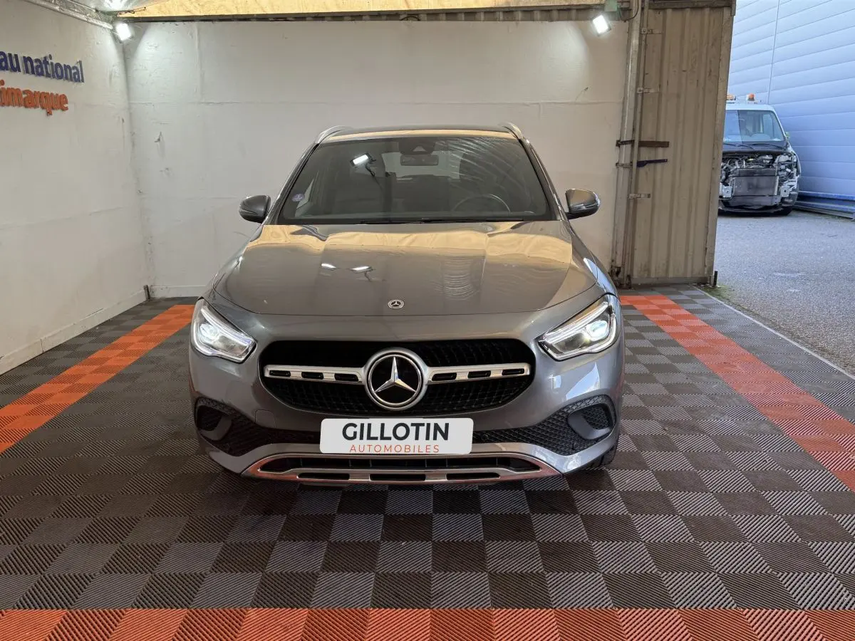 Vue avant d'une Mercedes GLA 250 e Business Line gris foncé, avec calandre et phares LED allumés.