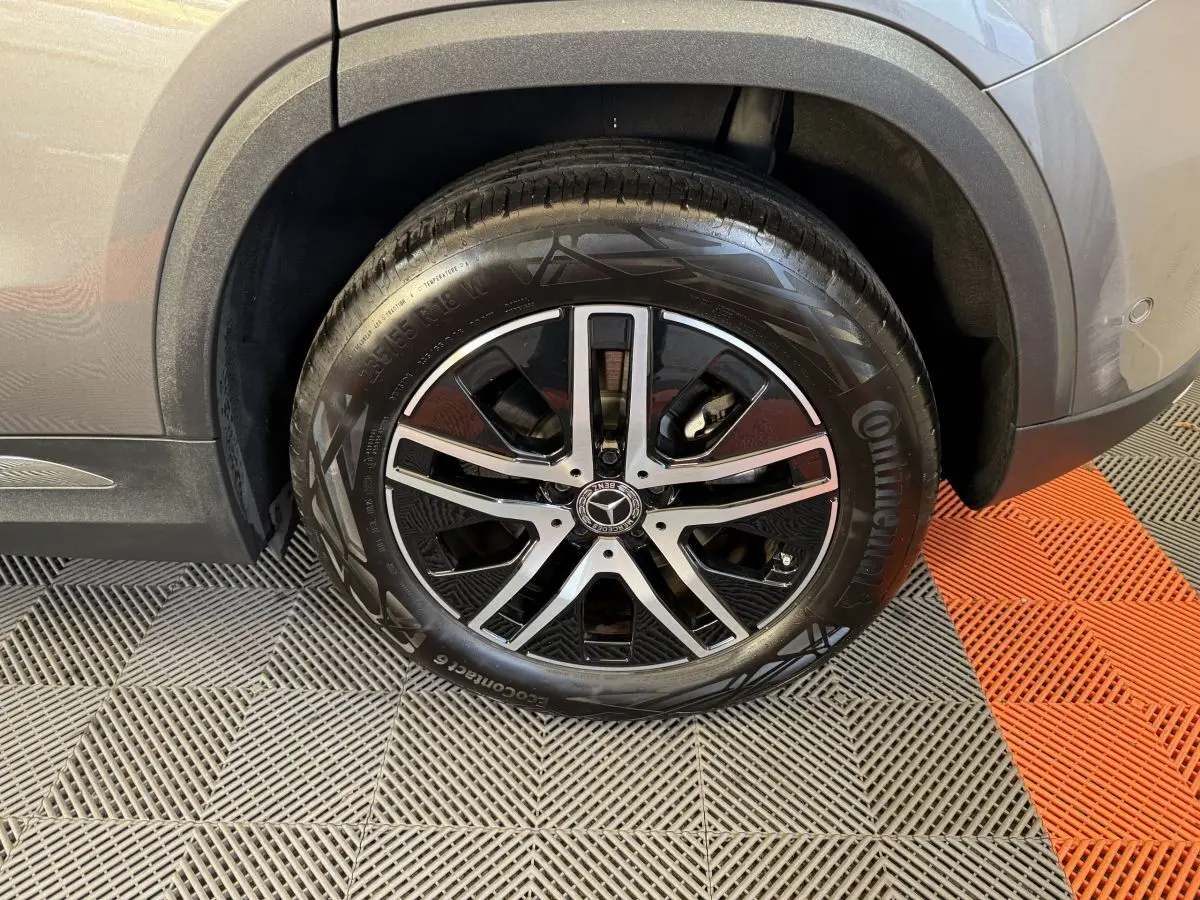Gros plan sur la roue arrière droite du Mercedes GLA 250 e Business Line gris foncé avec jante alliage noire et argent.