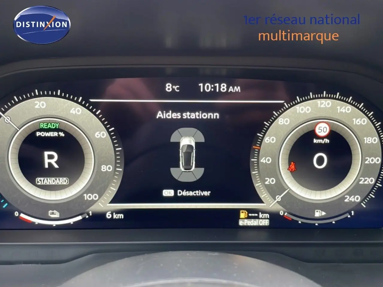 Tableau de bord numérique du Nissan Qashqai 2025 noir perle, affichant l'aide au stationnement et la vitesse à 0 km/h.