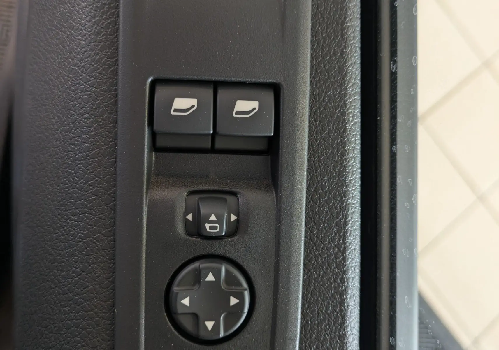 Gros plan sur les commandes de réglage des rétroviseurs électriques sur la porte côté conducteur du Citroën Jumpy Cabine Approfondie noir.