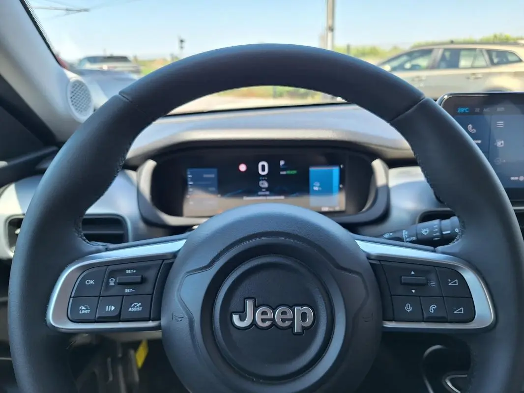 Vue rapprochée du volant noir du Jeep Avenger électrique 2025, avec commandes intégrées et tableau de bord numérique.
