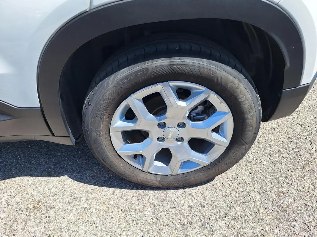 Gros plan sur la roue avant droite avec jante alliage 17 pouces du Jeep Avenger électrique blanc.