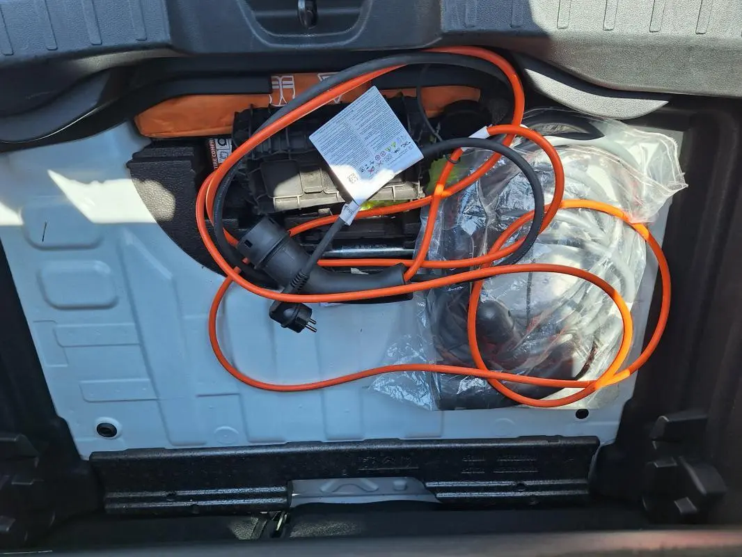 Vue du coffre du Jeep Avenger électrique blanc 2025, montrant le câble de recharge orange rangé.