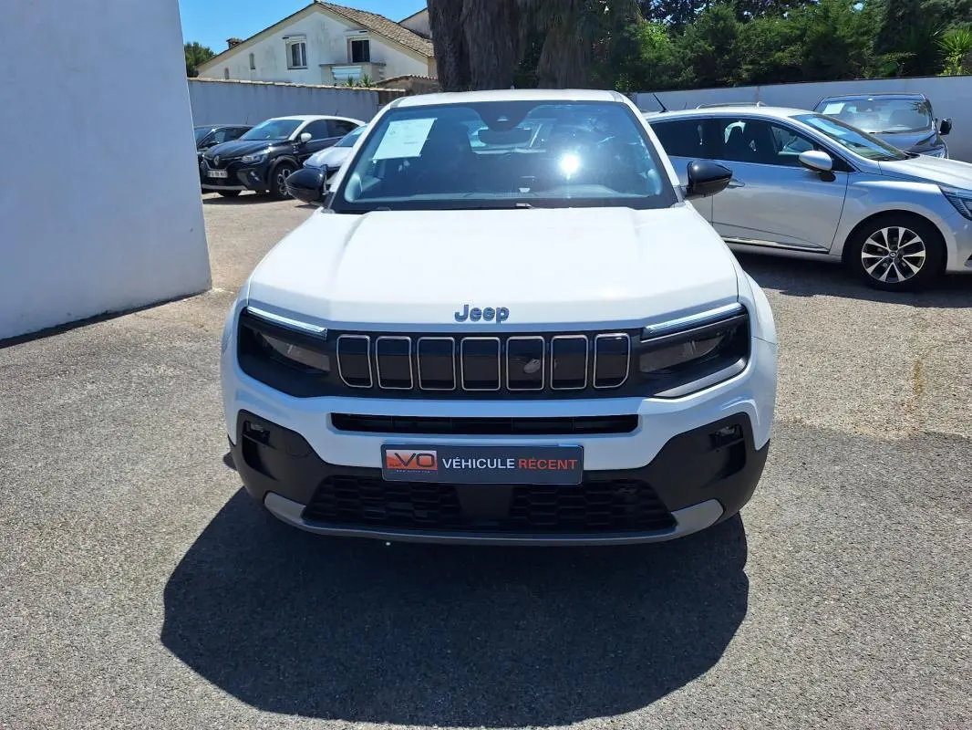 Vue de face d'un Jeep Avenger électrique blanc 2025 avec calandre noire et jantes alliage 17 pouces.
