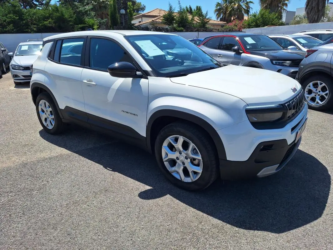 Vue 3/4 avant droit d'un Jeep Avenger électrique blanc avec jantes alliage 17 pouces et rétroviseurs noirs.
