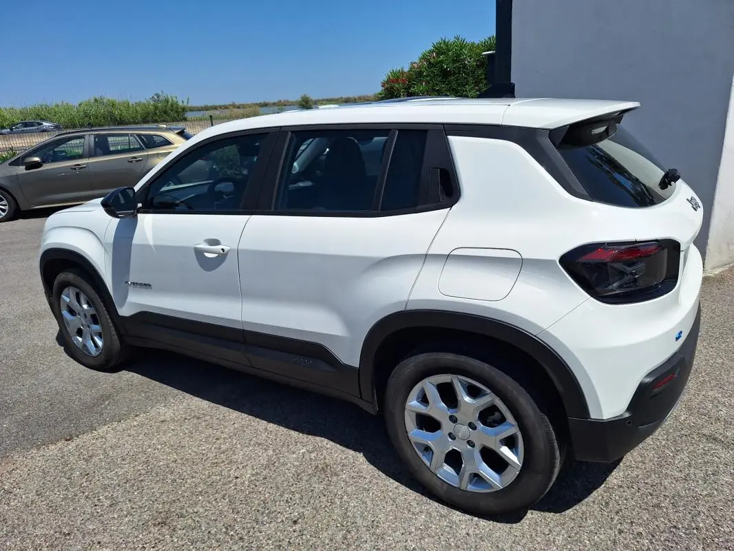 Jeep Avenger électrique blanc en 3/4 arrière droit, avec jantes alliage 17 pouces et vitres teintées.