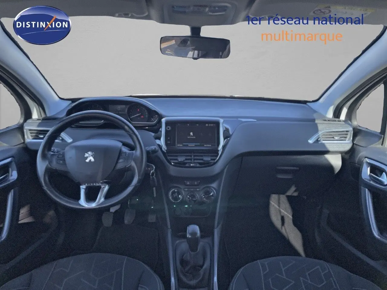 Vue intérieure avant du tableau de bord et volant noir du Peugeot 2008 blanc, avec écran tactile central et commandes manuelles.