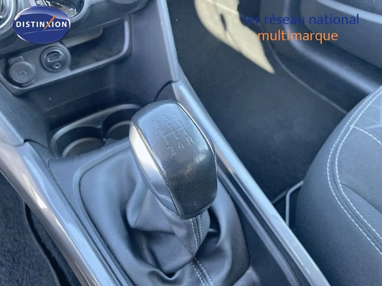 Le levier de vitesse manuel noir de la Peugeot 2008 blanc, vu en gros plan depuis le siège conducteur.