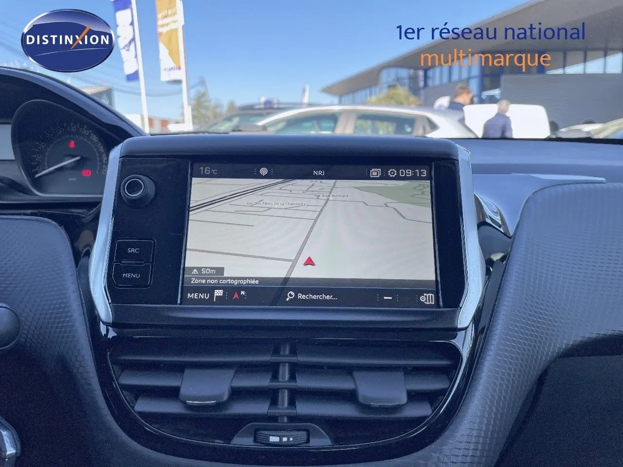 Tableau de bord du Peugeot 2008 blanc 2017 avec écran GPS tactile et commandes intégrées, vue frontale intérieure.