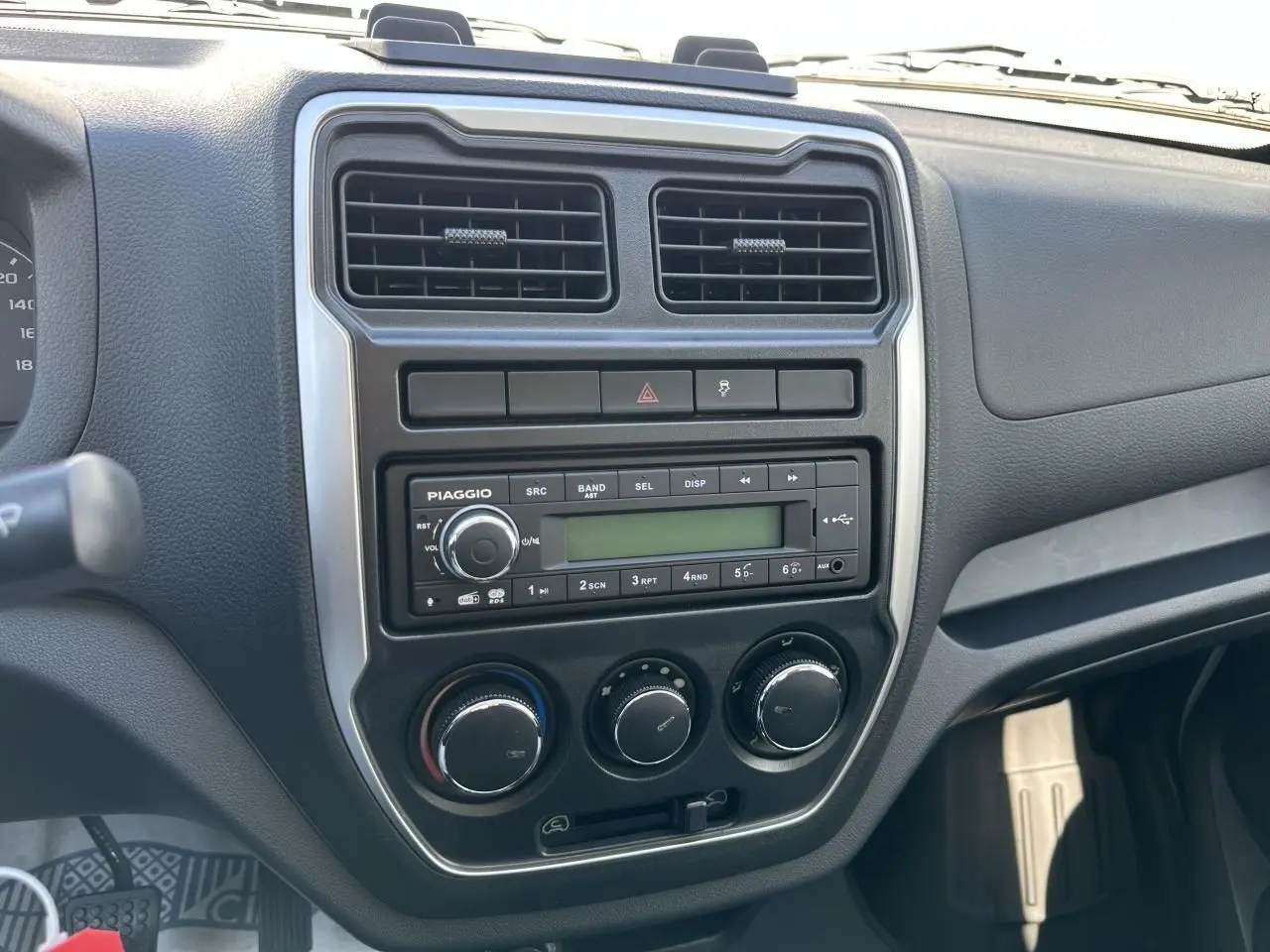 Tableau de bord du Piaggio Porter 2024, vue de face sur la console centrale avec radio et commandes climatiques.