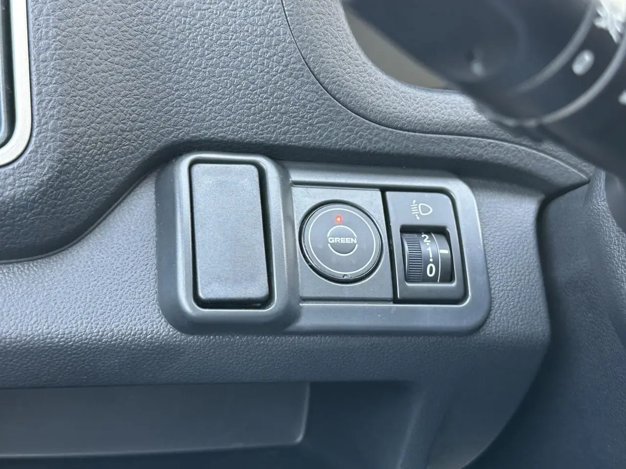 Détail du tableau de bord du Piaggio Porter 2024 montrant les commandes d'éclairage et mode Green en plastique noir.