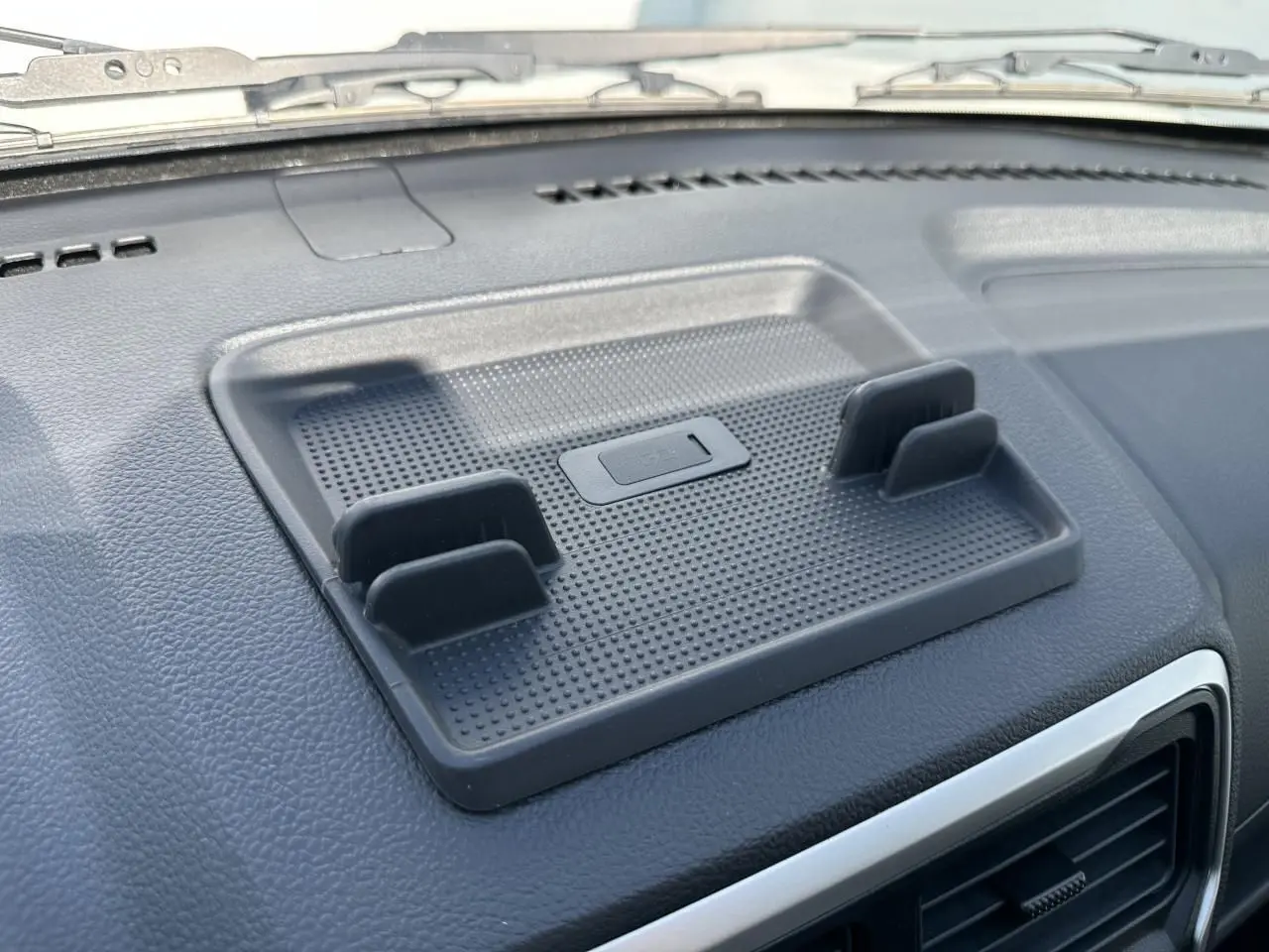 Support de smartphone noir fixé sur le tableau de bord du Piaggio Porter blanc, vue rapprochée intérieure côté conducteur.