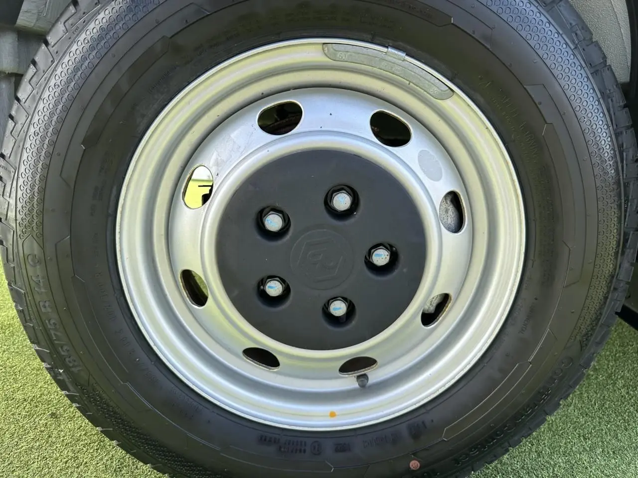 Gros plan sur la roue acier avec logo Piaggio au centre du camion blanc Porter NP6 2024.