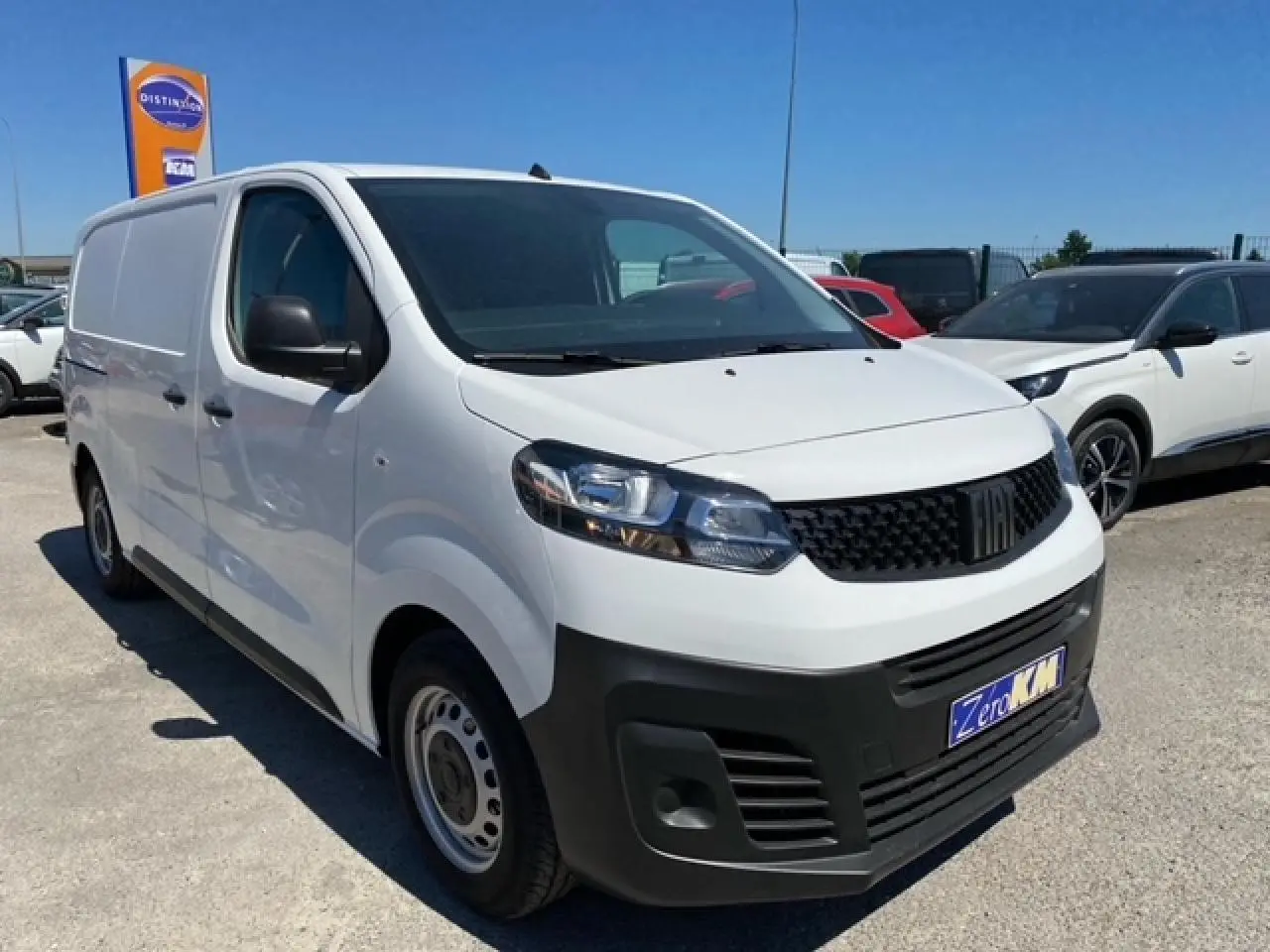 Fourgon blanc FIAT Scudo 2022 vu en 3/4 avant droit avec calandre noire et jantes acier simples.