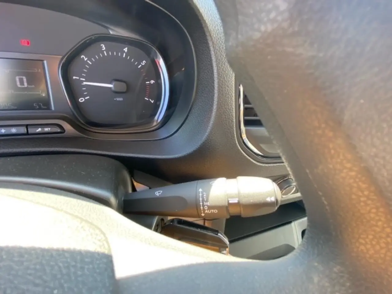 Gros plan sur le commodo d’essuie-glace et le compte-tours du tableau de bord du Fiat Scudo Fourgon blanc.