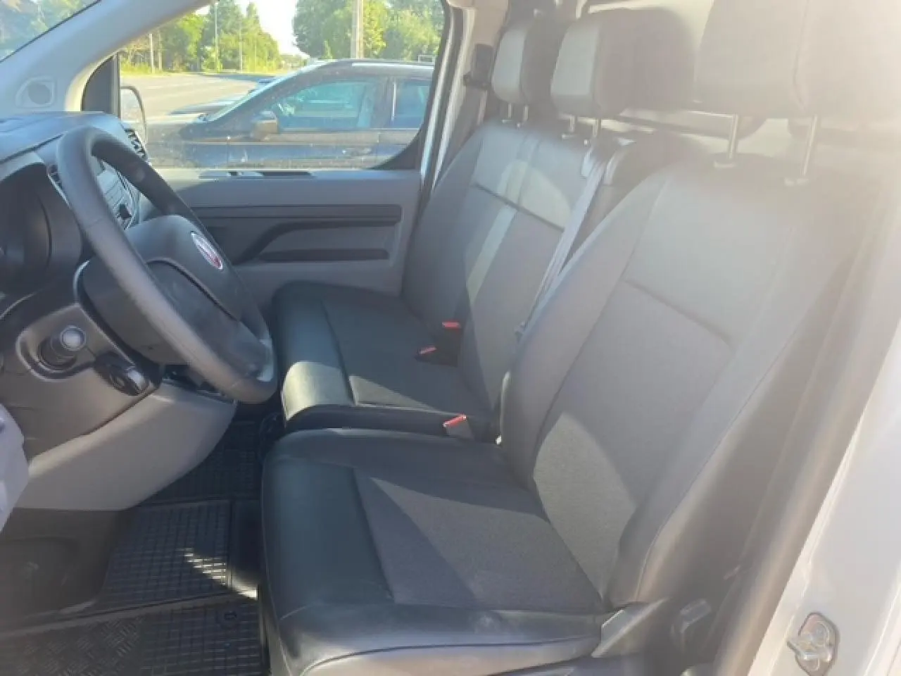 Vue intérieure côté conducteur du Fiat Scudo Fourgon blanc 2022, banquette passager 2 places Moduwork en tissu noir.