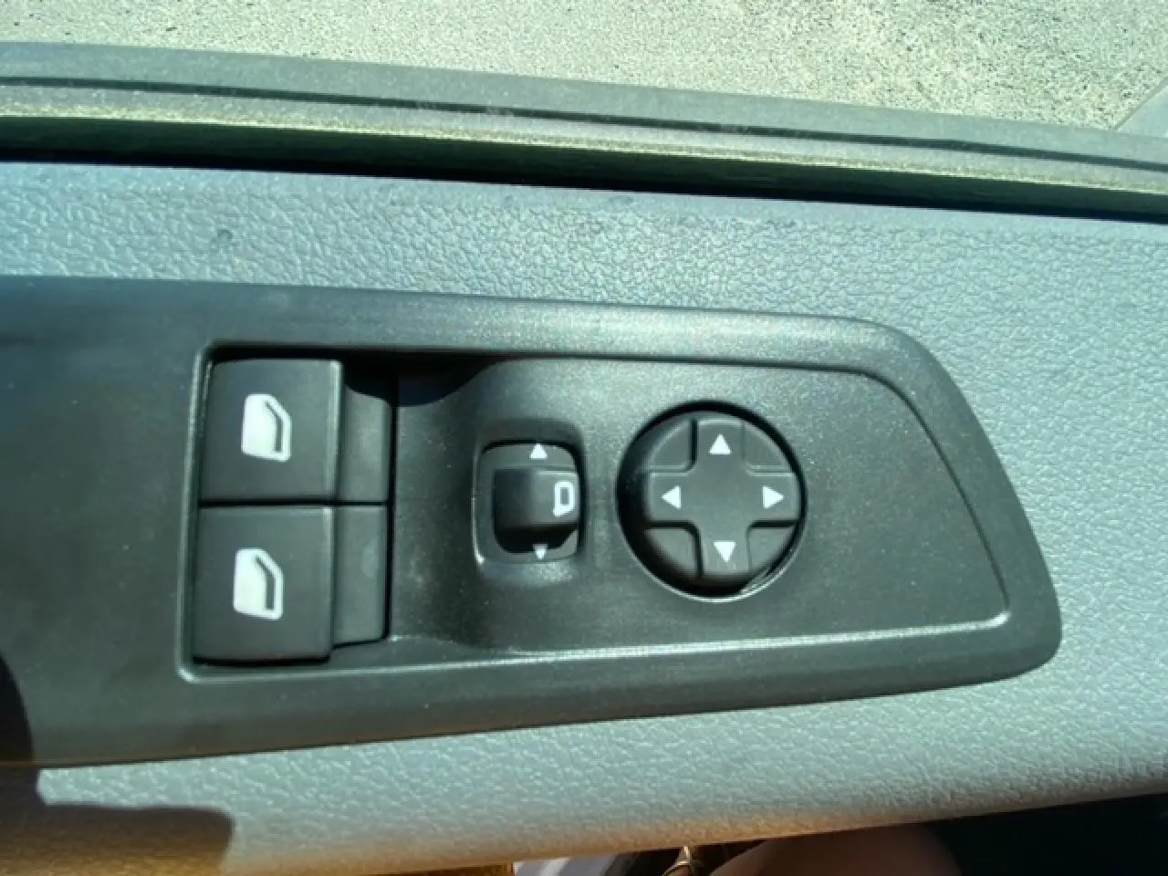 Gros plan sur les commandes de réglage des rétroviseurs et des vitres du FIAT Scudo Fourgon blanc, version 2022.