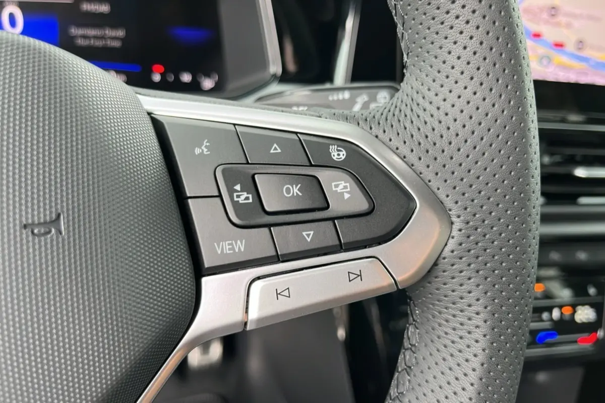 Gros plan sur les commandes à droite du volant perforé du Volkswagen T-Roc gris indium 2025 R-Line Black.