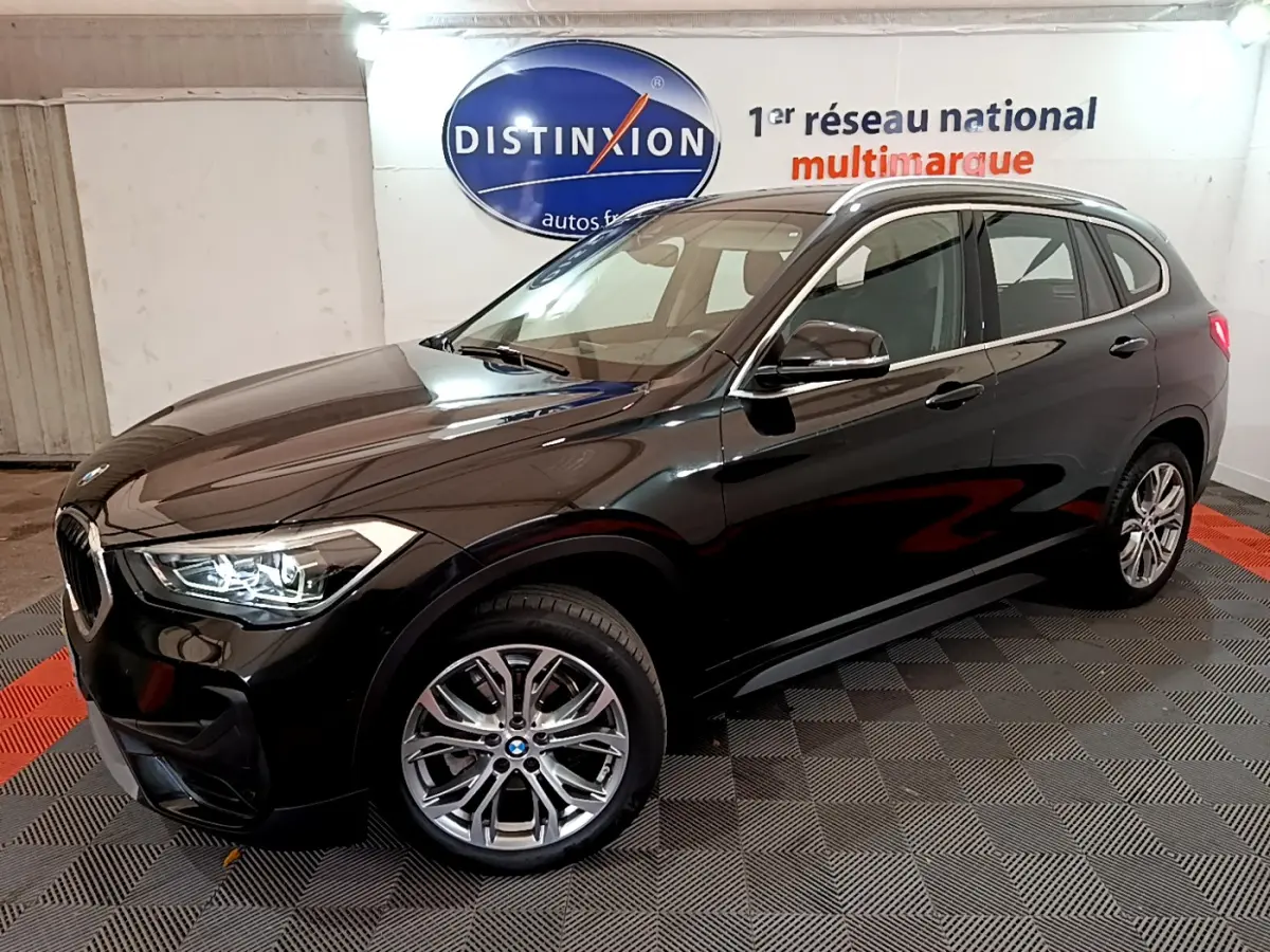 BMW X1 sDrive16d noir en 3/4 avant droit, mettant en valeur ses phares LED et ses rétroviseurs électriques chauffants.