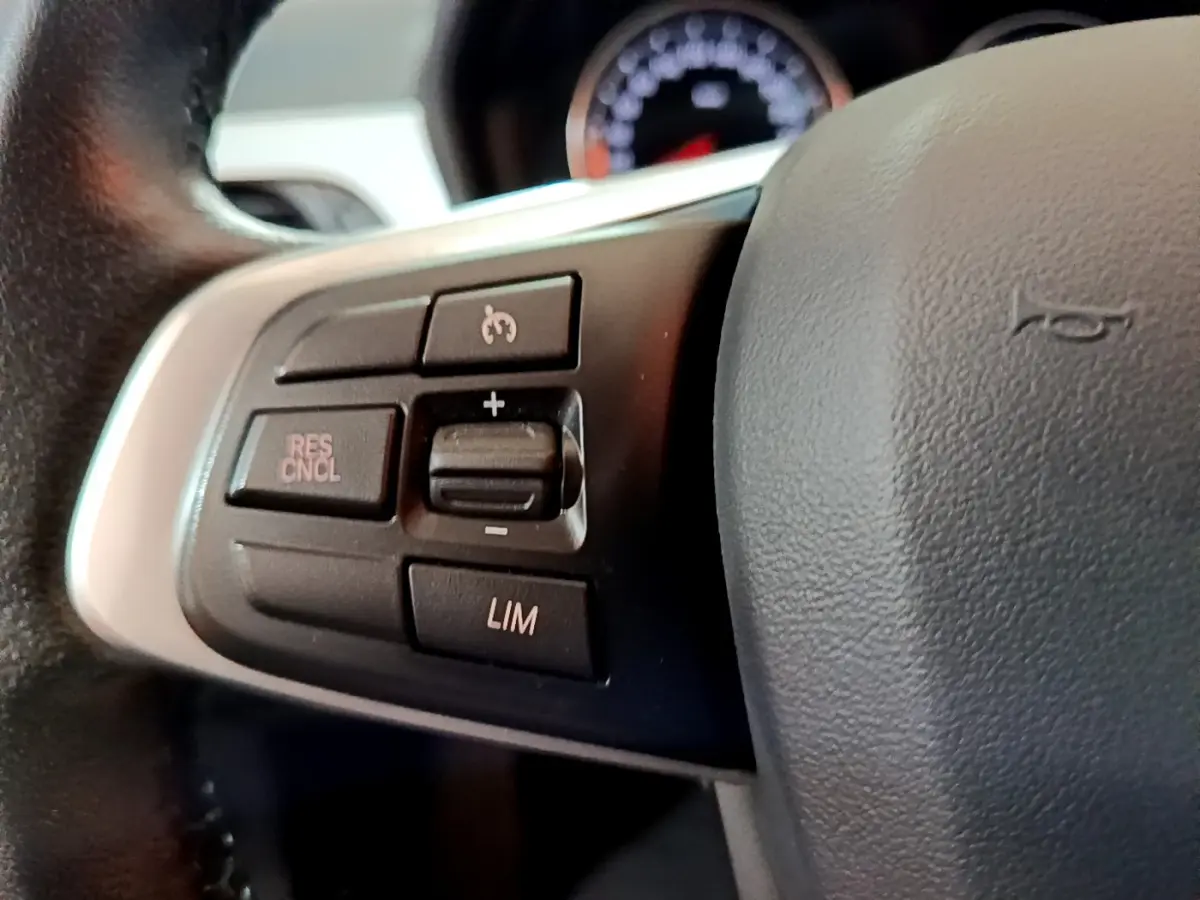 Gros plan sur les commandes de régulateur de vitesse au volant cuir noir d’un BMW X1 sDrive16d Lounge 2021.