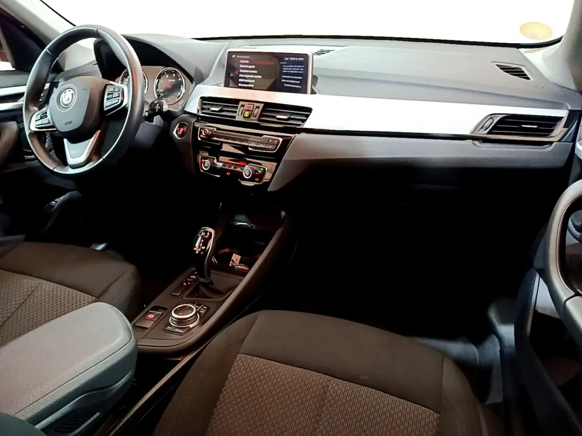 Intérieur noir de BMW X1 sDrive16d 2021 vu côté conducteur, avec tableau de bord moderne et écran central.