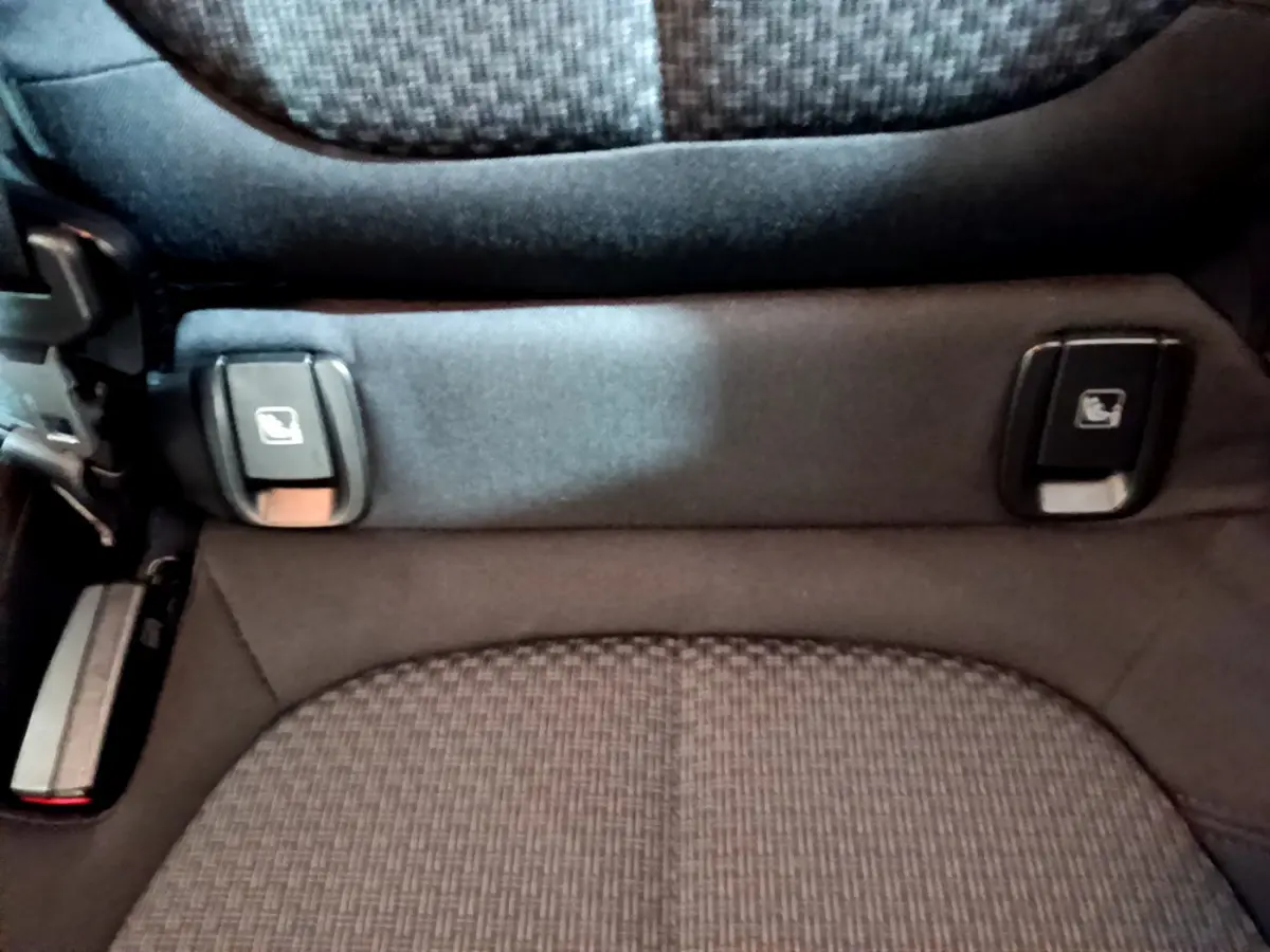 Gros plan sur la commande de rabattement des sièges arrière du BMW X1 sDrive16d Lounge noir, détail intérieur.