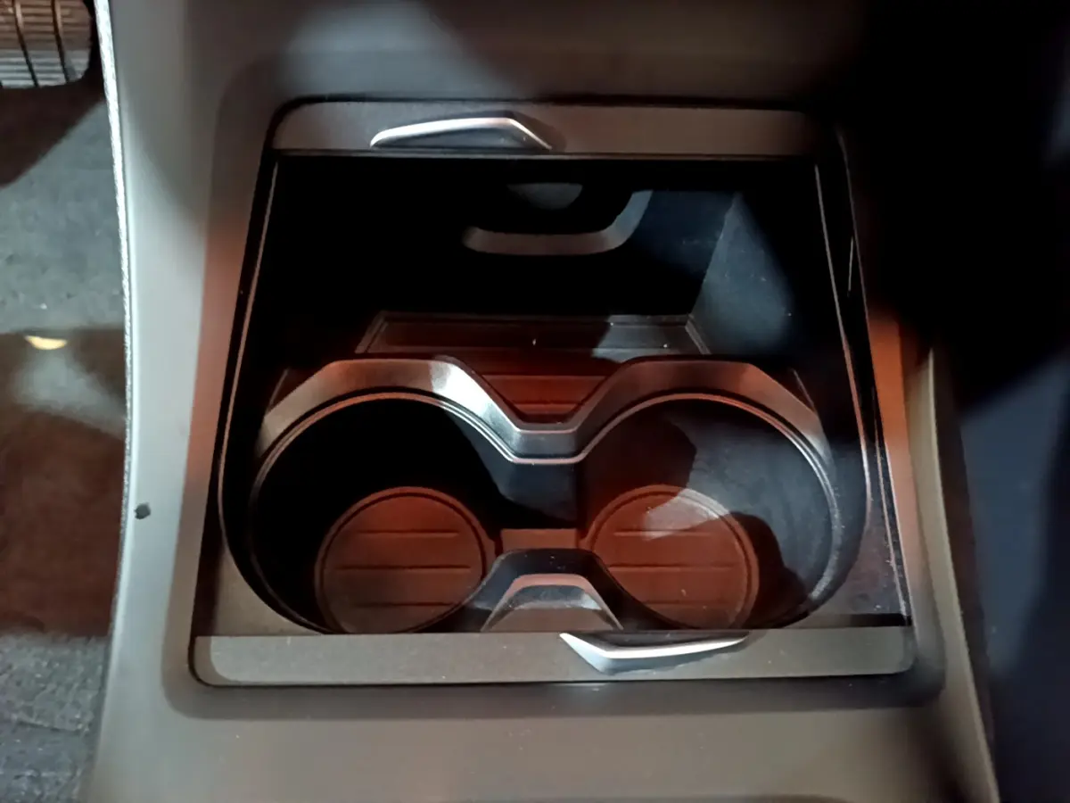 Gros plan sur les porte-gobelets noirs intégrés à la console centrale du BMW X1 sDrive16d Lounge DKG7 2021.