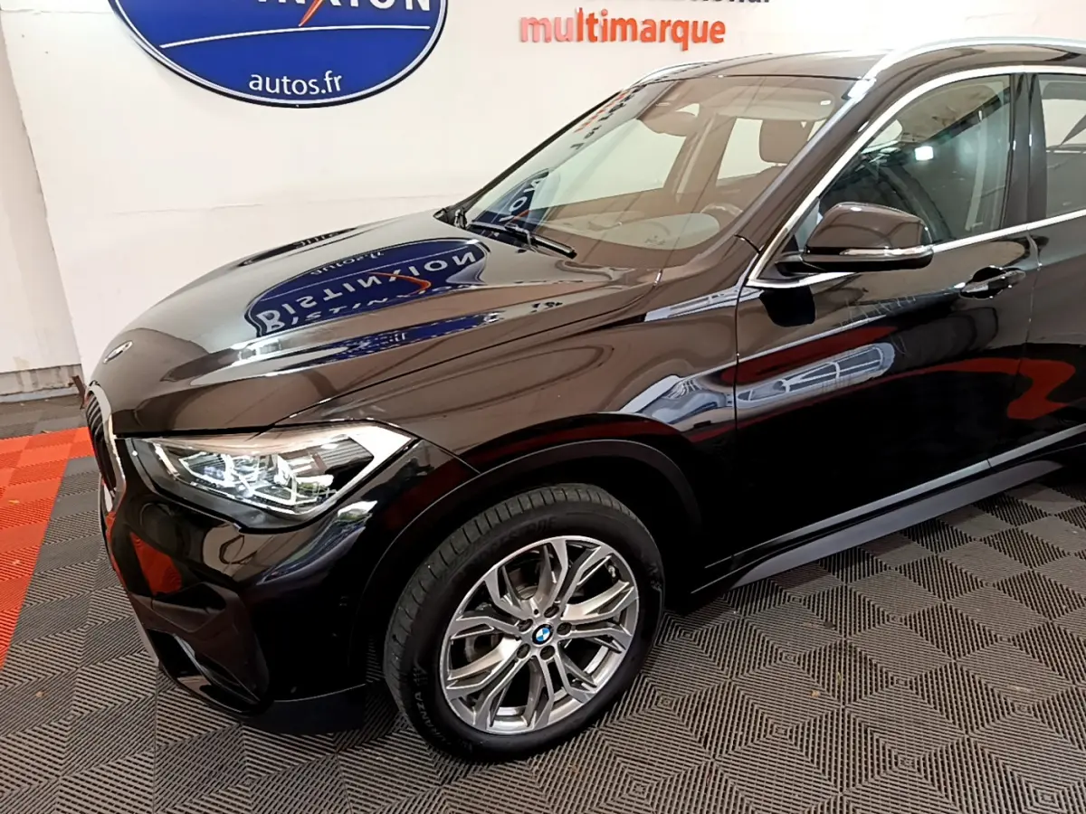BMW X1 sDrive16d noir en 3/4 avant droit, mettant en valeur ses phares LED et jantes alliage.