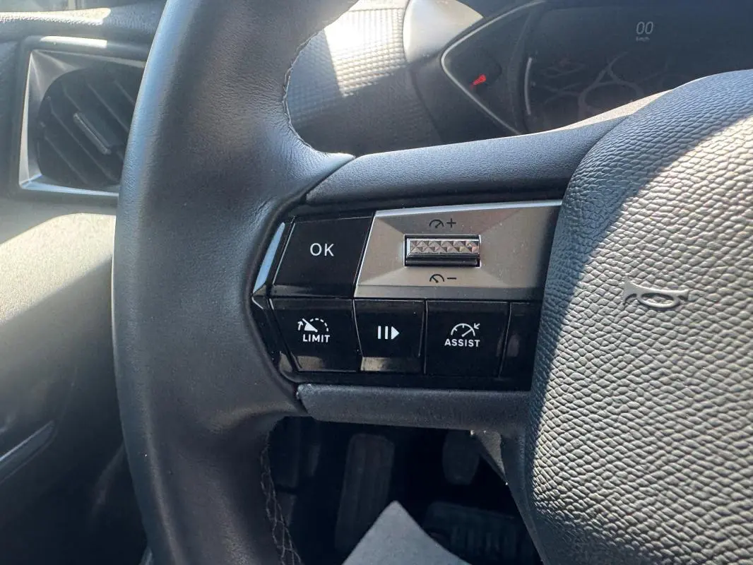 Gros plan sur le volant noir de la DS3 100 BVM6 Bastille 2024, montrant les commandes de régulateur et limiteur de vitesse.