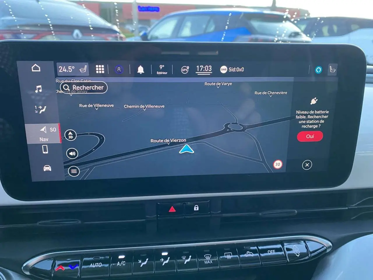 Écran tactile central du tableau de bord du Fiat 500 électrique blanc, affichant la navigation GPS en plein jour.