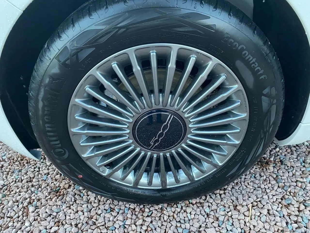 Gros plan sur la jante alliage 16'' Icône argentée d'une FIAT 500 électrique blanche, vue côté roue avant.