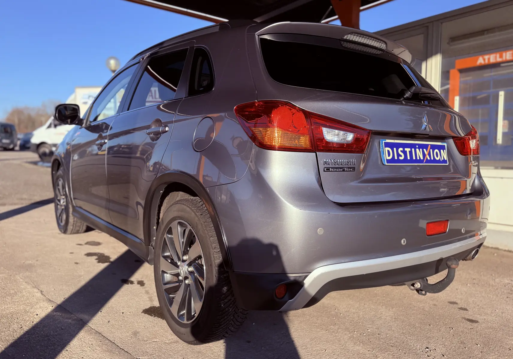 Vue 3/4 arrière droite du Mitsubishi ASX gris 2015 avec attelage et jantes alliage visibles.