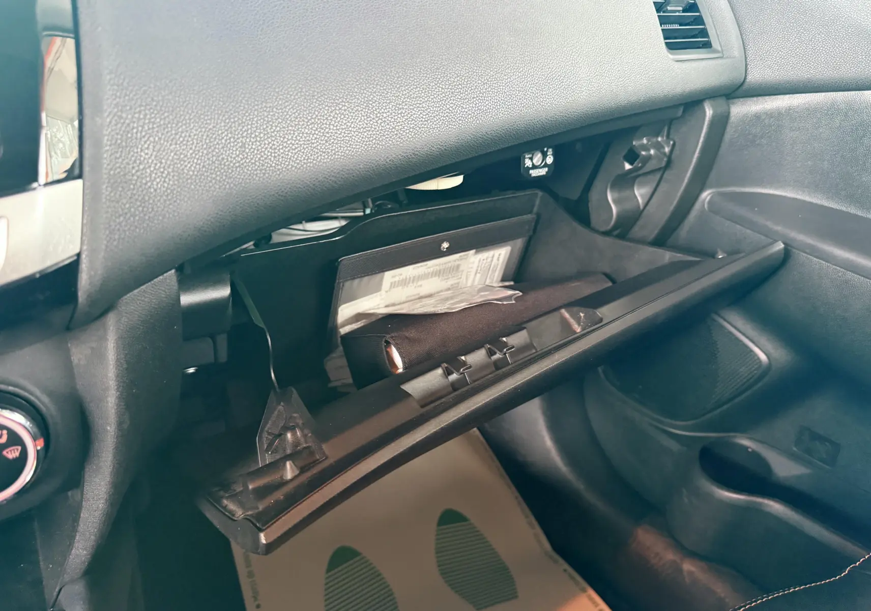 Gros plan de la boîte à gants ouverte côté passager du Mitsubishi ASX 2015 avec intérieur noir.