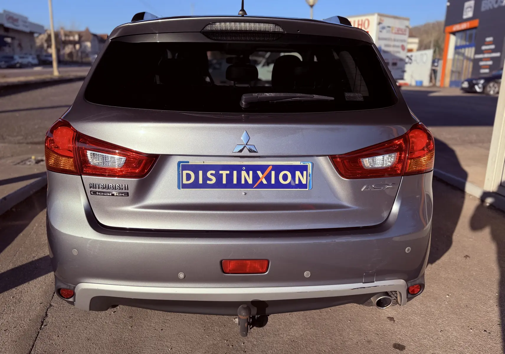 Vue arrière d'un Mitsubishi ASX gris 2015 avec feux rouges et attelage visible au centre.
