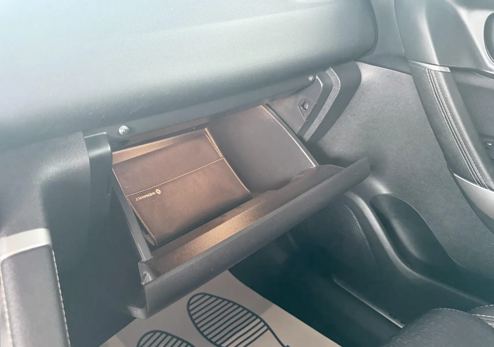 Intérieur côté passager du Renault Kadjar 2016, boîte à gants ouverte avec pochette Renault visible.