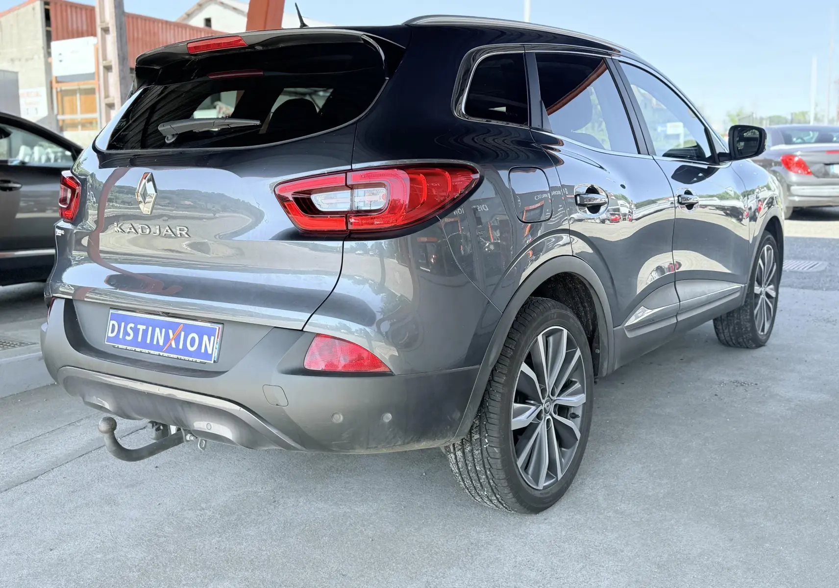 Renault Kadjar gris en 3/4 arrière droit, avec attelage de remorque visible et jantes alliage.