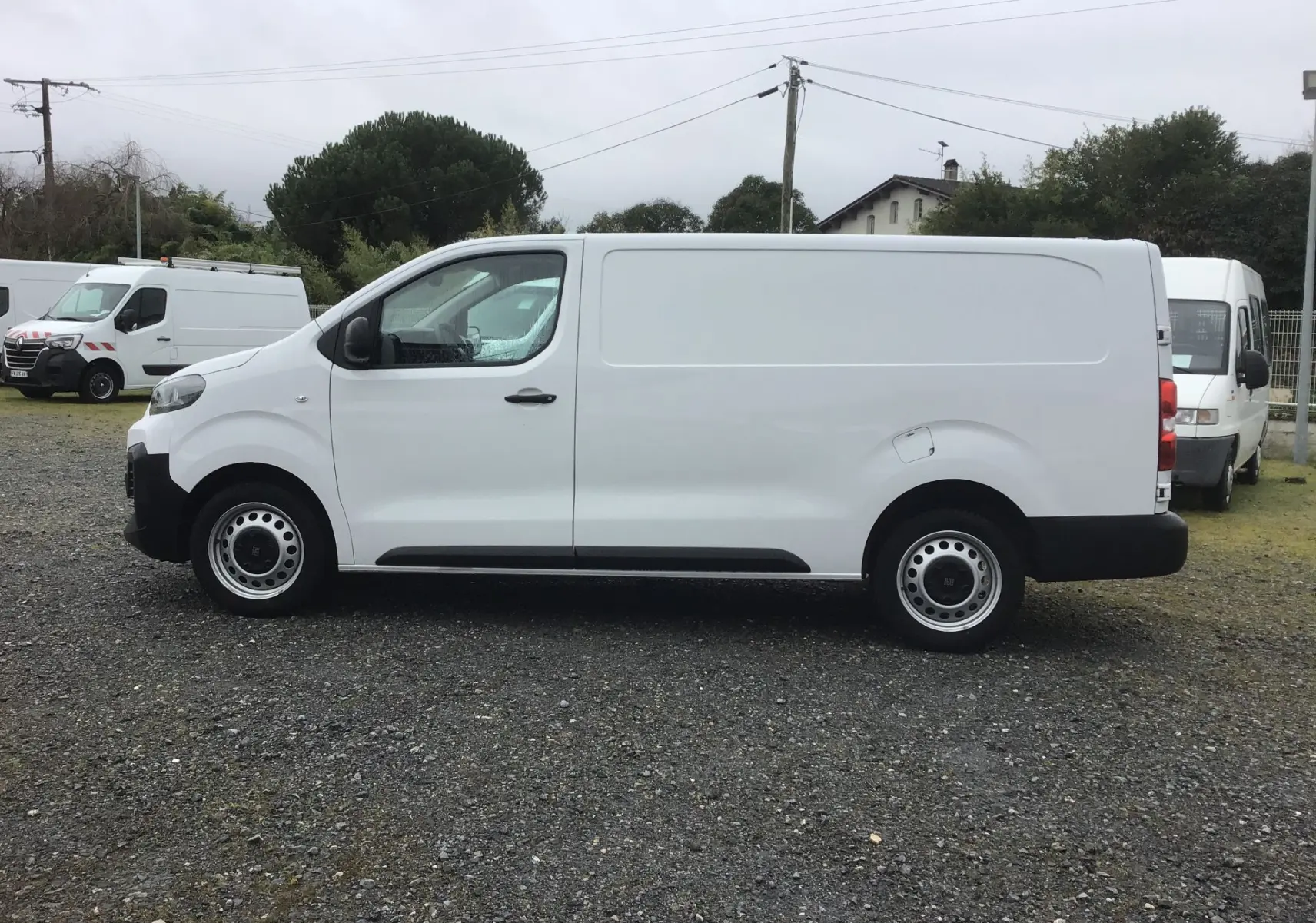 Vue de profil côté gauche d’un FIAT Scudo Fourgon blanc 2024, avec carrosserie lisse et roues acier noires.