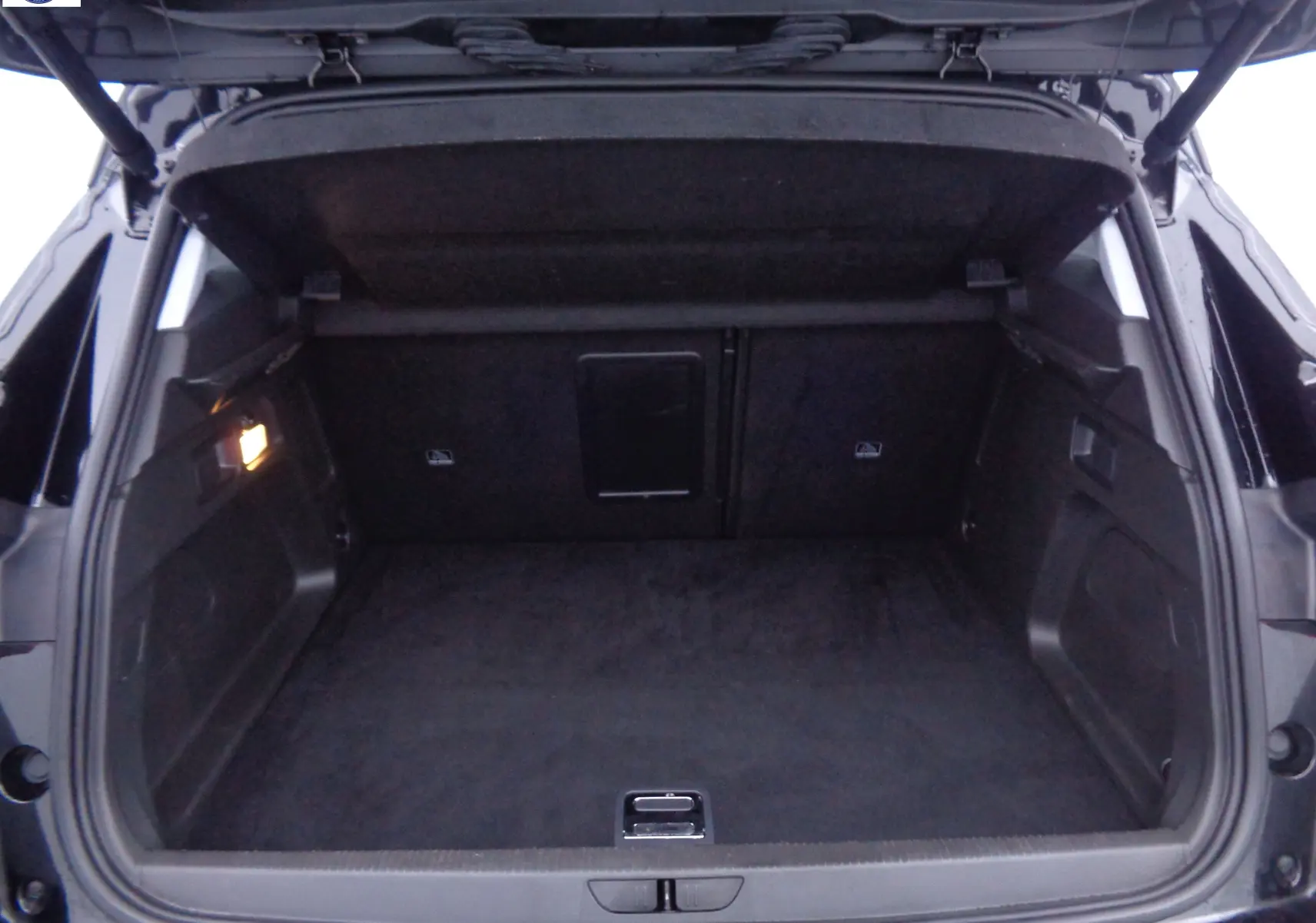 Coffre ouvert de l'Opel Grandland X noir métal, vue arrière montrant l'espace de chargement vide et l'éclairage intérieur.