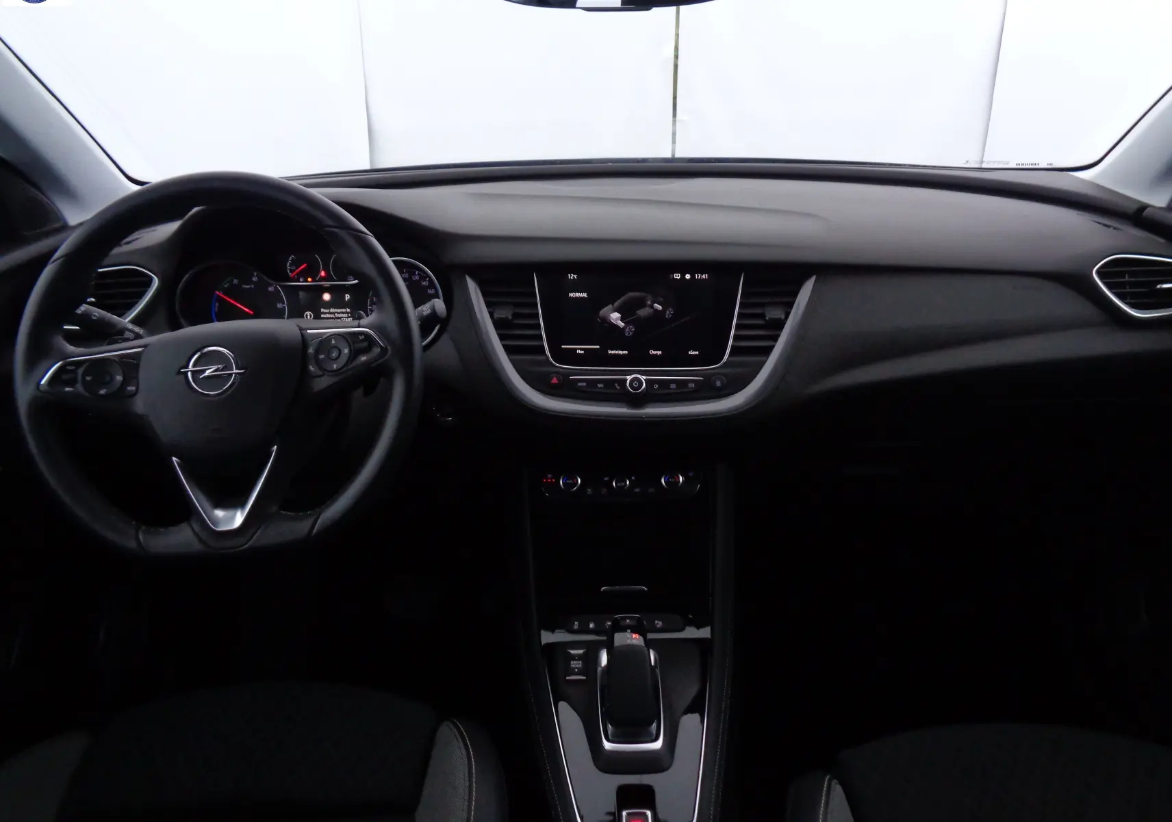 Intérieur noir de l'Opel Grandland X 1.6 Hybrid Turbo 2021, vue frontale sur tableau de bord et volant multifonction.
