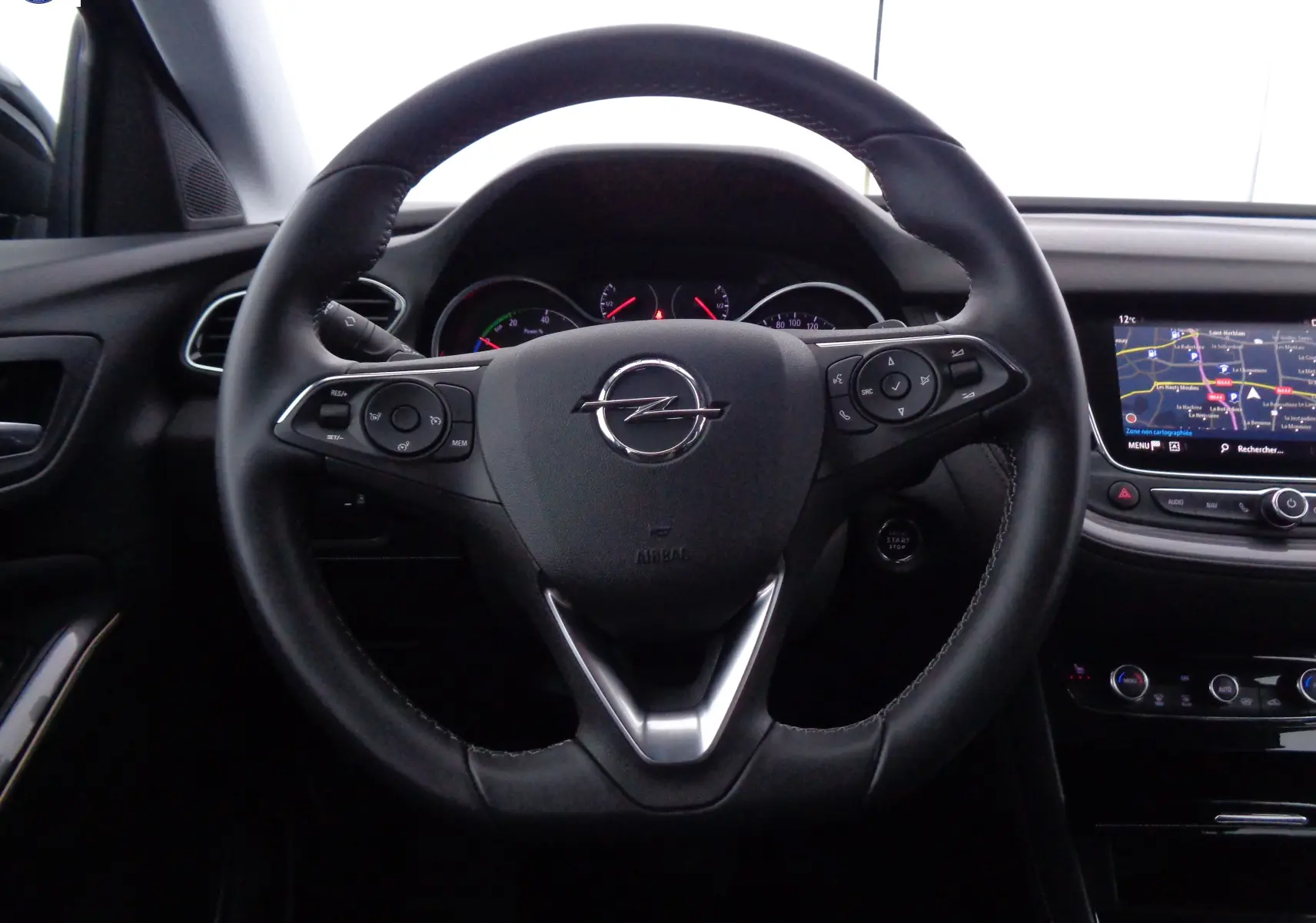 Vue centrée sur le volant noir de l'Opel Grandland X 1.6 Hybrid Turbo 2021 avec tableau de bord et écran GPS.