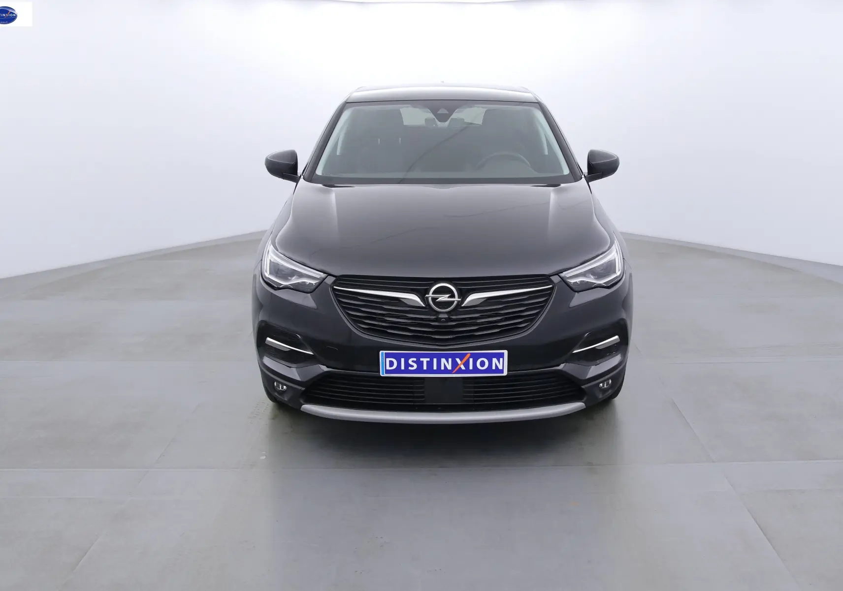 Vue frontale d'un Opel Grandland X noir métal, hybride rechargeable, avec calandre et phares LED distinctifs.